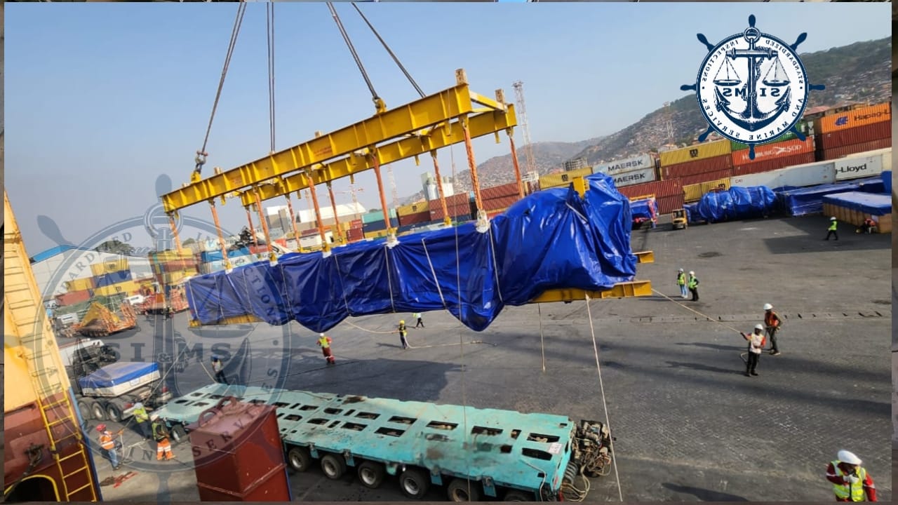 Tarpaulin-wrapped project cargo lifted by spreader beam at Freetown port