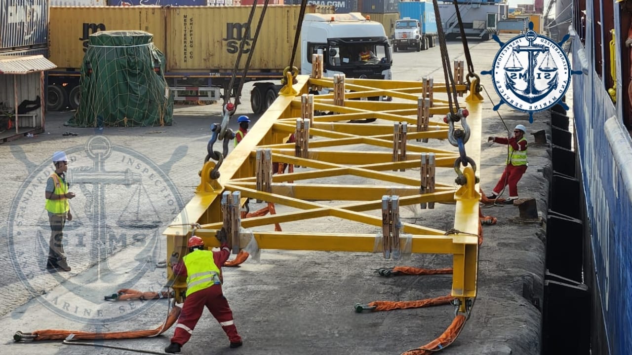 Riggers guiding a lifting frame into position on the quay